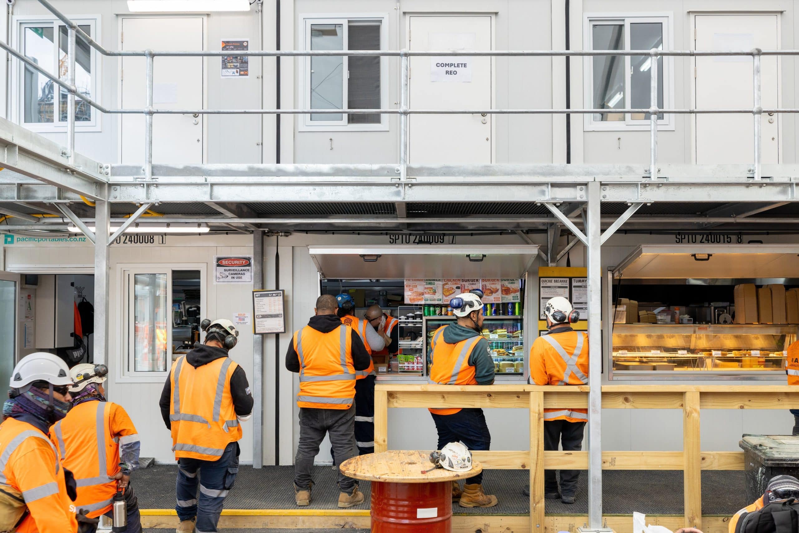 Construction crew lining up to have lunch at a portable break room installed by Pacific Portable Buildings.